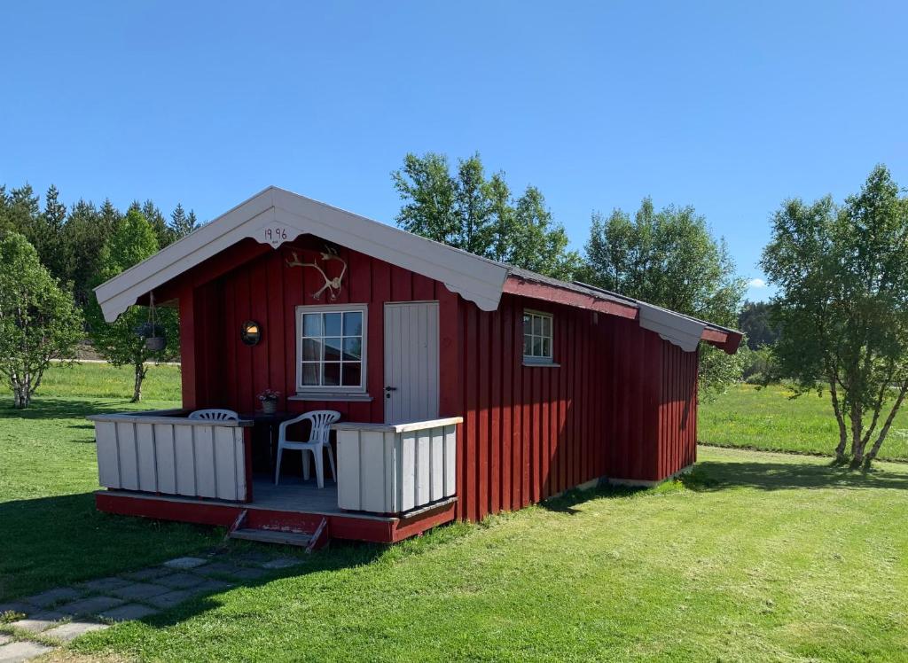 a red shed with a table in a field at Harekroken in Tynset
