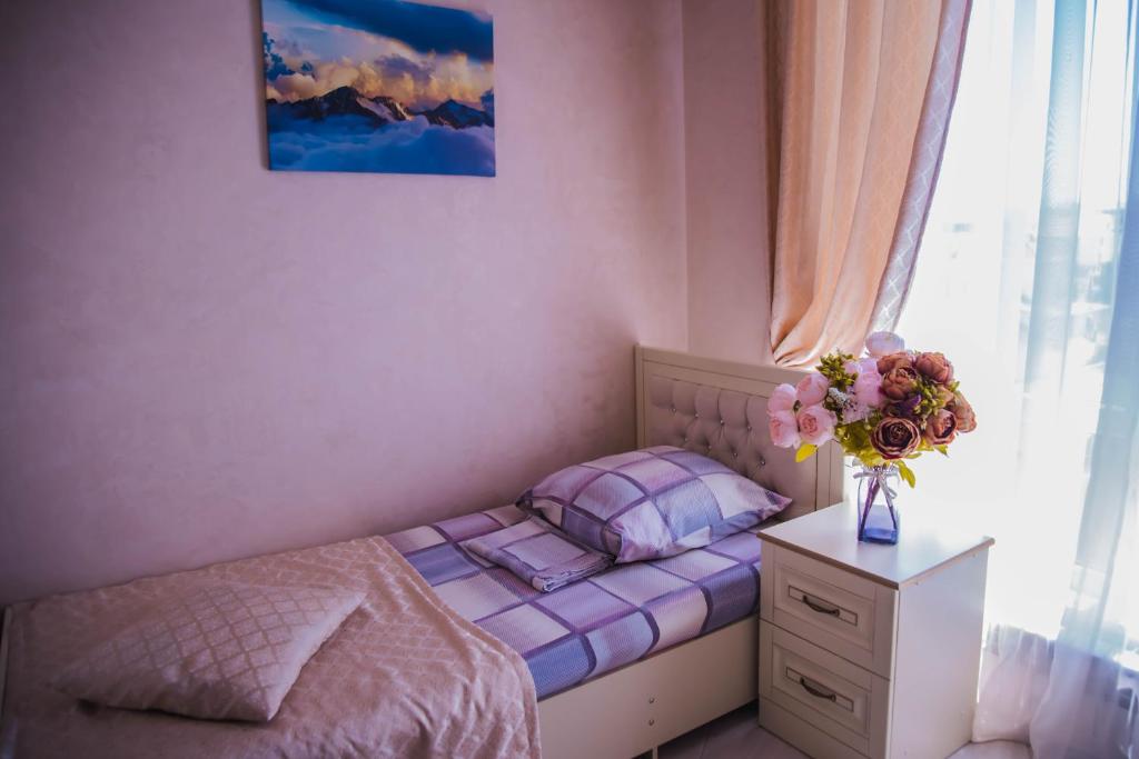 アドレルにあるApartments on Kuvshinok 8の小さなベッドルーム(ベッド1台、花瓶付)