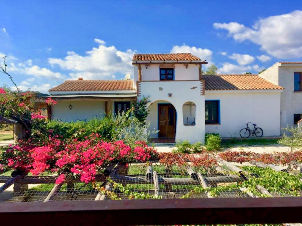 una casa con flores rosas delante de ella en Tentadore, en La Caletta