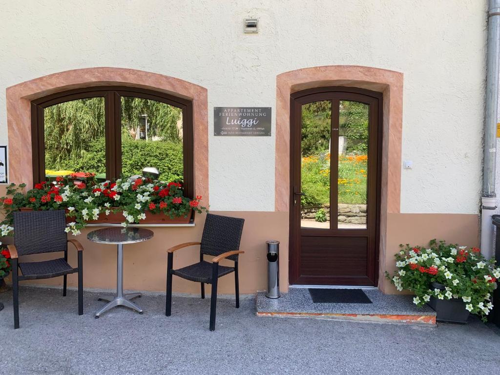 einen Tisch und Stühle vor einem Gebäude mit Blumen in der Unterkunft Appartement Luiggi in Innsbruck