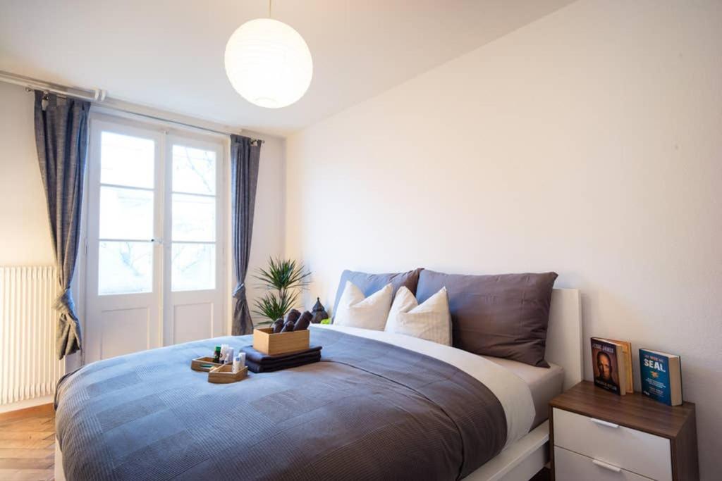 ein Schlafzimmer mit einem großen Bett und einem Fenster in der Unterkunft -TheUrbanist- in Bern