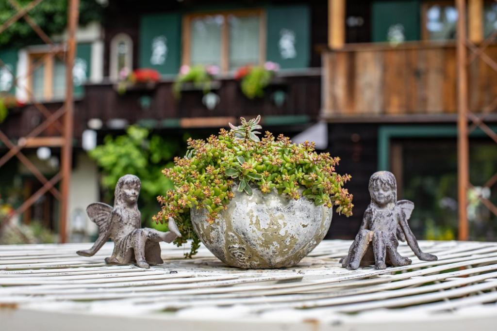 drie beeldjes op een tafel naast een potplant bij Alpenrelax Haus Weidmannsheil wohnen im romantischen Forsthaus in Werfen