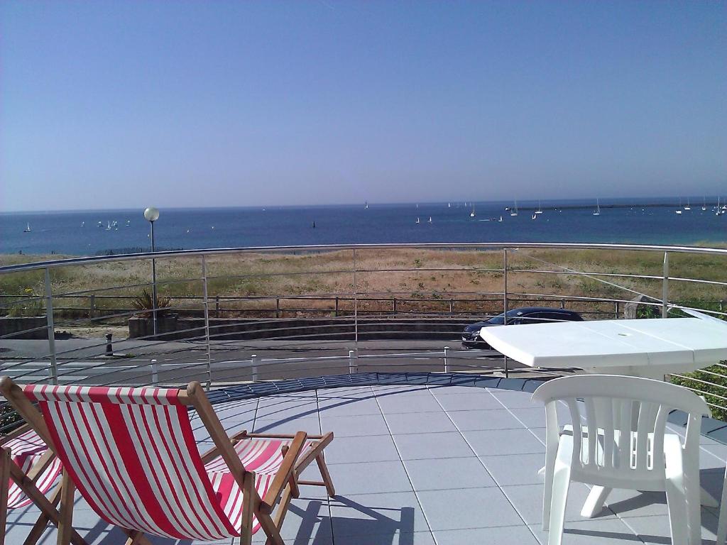 a patio with a table and chairs and the ocean at Villa Keris - Face Océan in Audierne