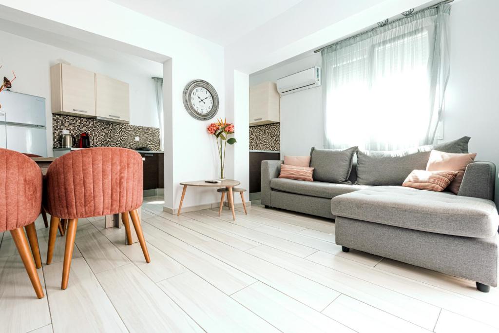 a living room with a couch and a table at Design Suites Efharis (Sauvignon) in Nea Peramos