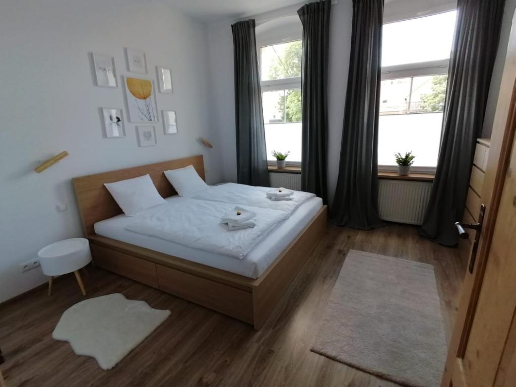 a bedroom with a bed with two towels on it at Apartament KurOrt Gaja in Jelenia Góra