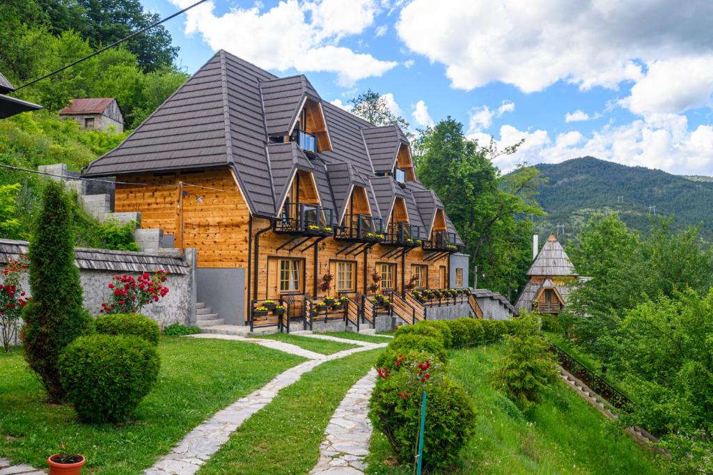 una grande casa in legno con tetto a gambero di Neva Apartments a Mokra Gora