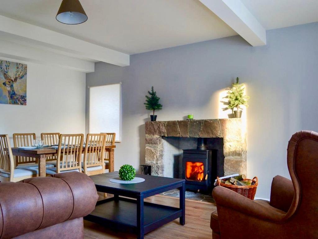 a living room with a couch and a fireplace at The Coolins cottage with wood burner in Strathcarron