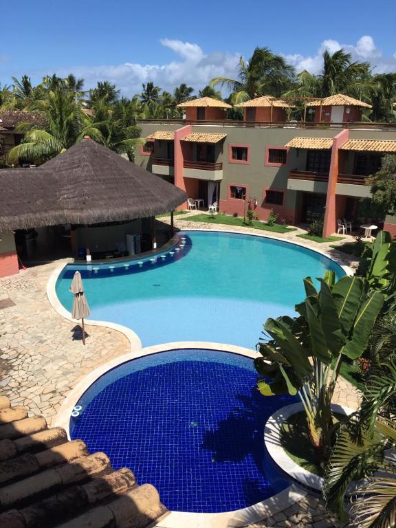 una piscina frente a un complejo en Cond Residencial Resort Pipa Chalés Triplex - Centro de Pipa, en Pipa