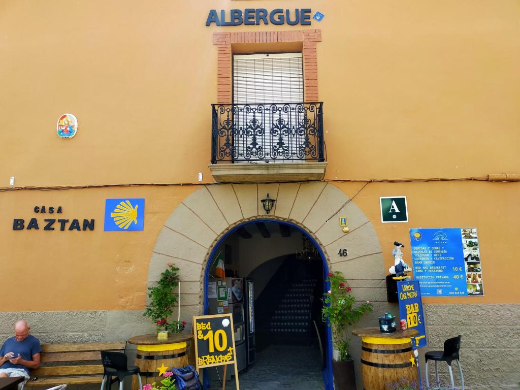 ALBERGUE CASA BAZTAN في Uterga: مدخل لمبنى فيه بلكونه وباب