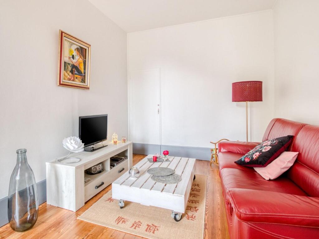 - un salon avec un canapé rouge et une télévision dans l'établissement Peaceful holiday home near the forest, à Bligny-sur-Ouche