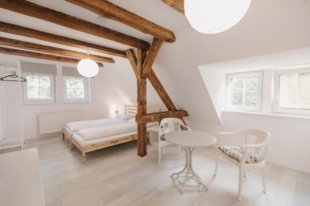 um quarto com uma cama, uma mesa e cadeiras em Leśniki em Babimost