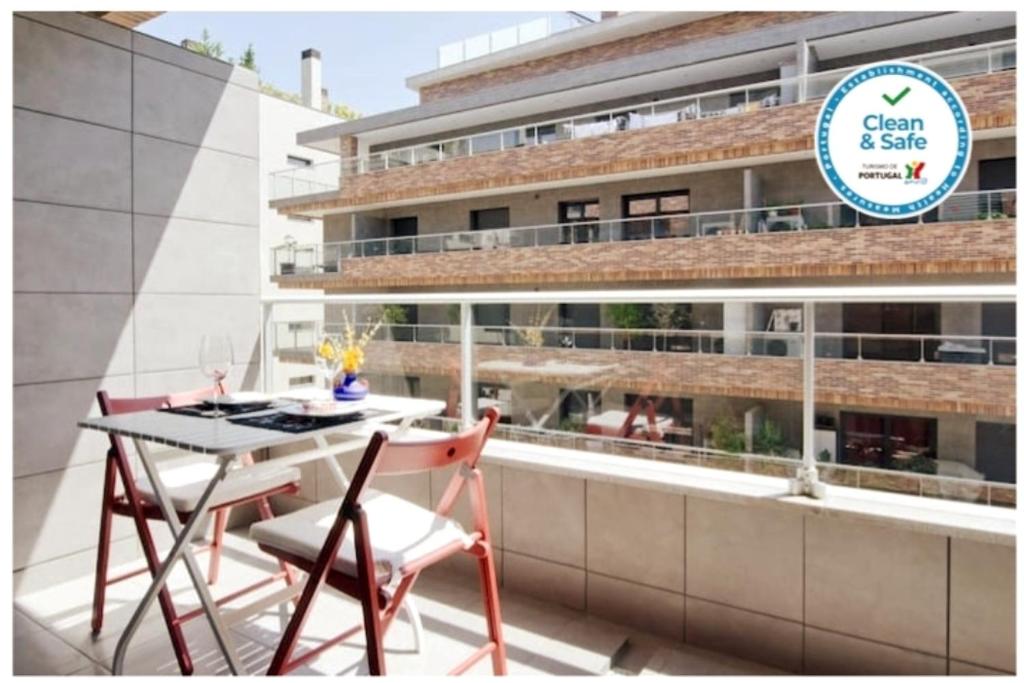 - un balcon avec une table et des chaises dans l'établissement Parque Nações / Jardins Cristo Rei, à Lisbonne