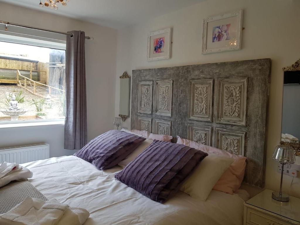 Un dormitorio con una cama con almohadas moradas. en Abbey Field - Cyanacottages en Whitby