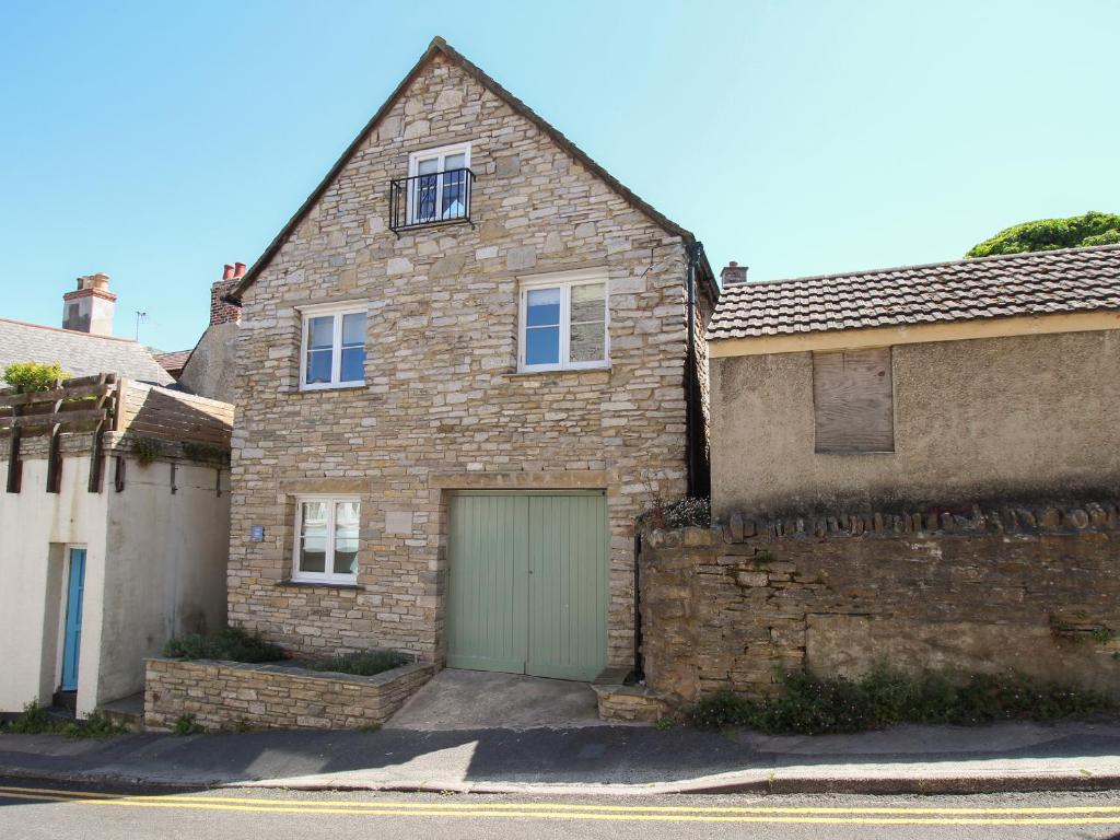 uma casa de tijolos com uma garagem verde em Swanage Driftwood em Swanage