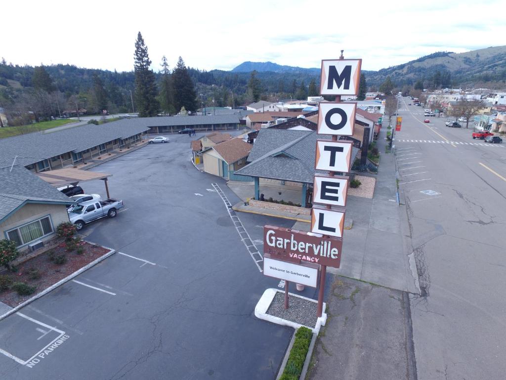 ein Motelschild vor einem Parkplatz in der Unterkunft Motel Garberville in Garberville