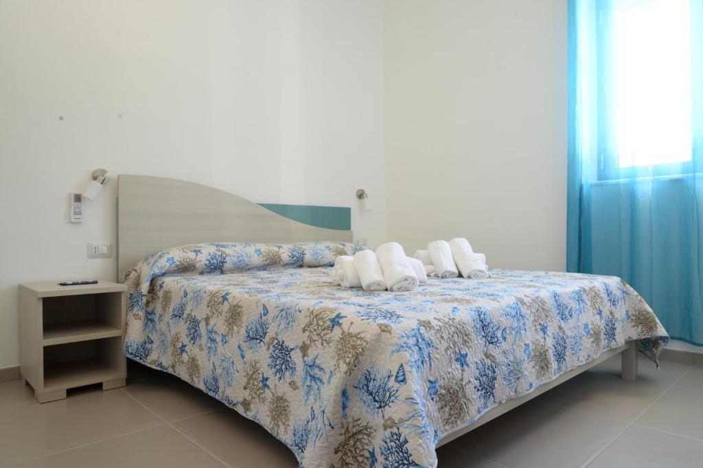 a bedroom with a bed with a blue and white blanket at Villa Giovanni in Palinuro