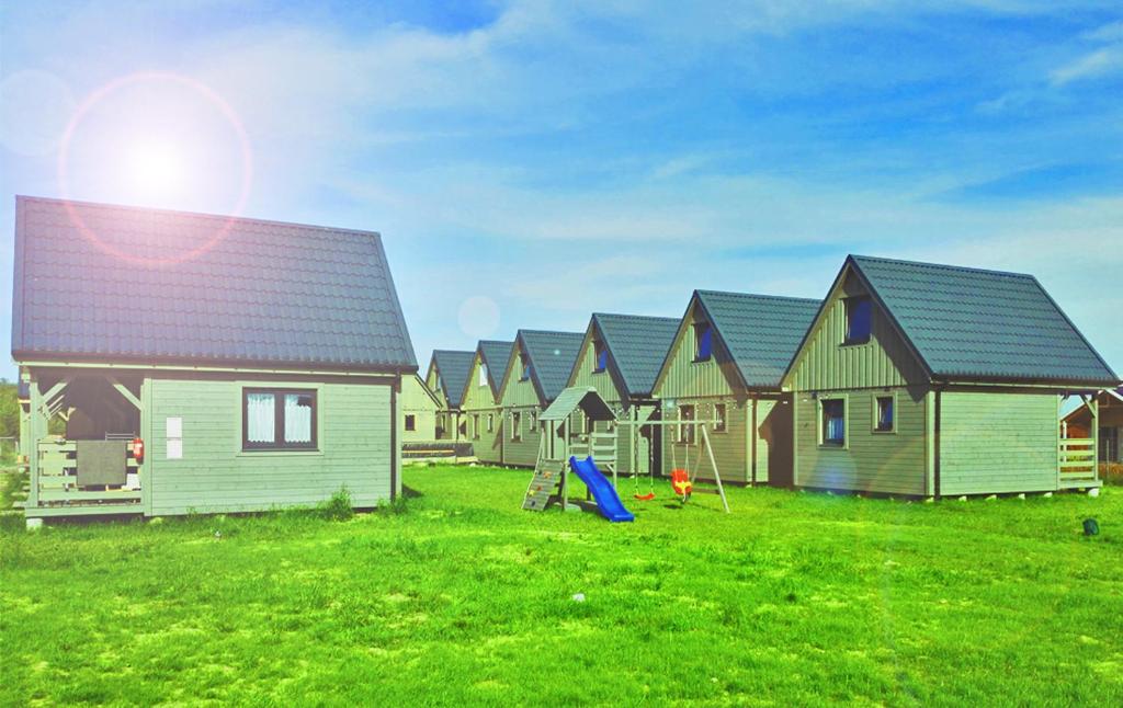 a row of houses in a field of green grass at Jaśminowa Przystań in Wicie