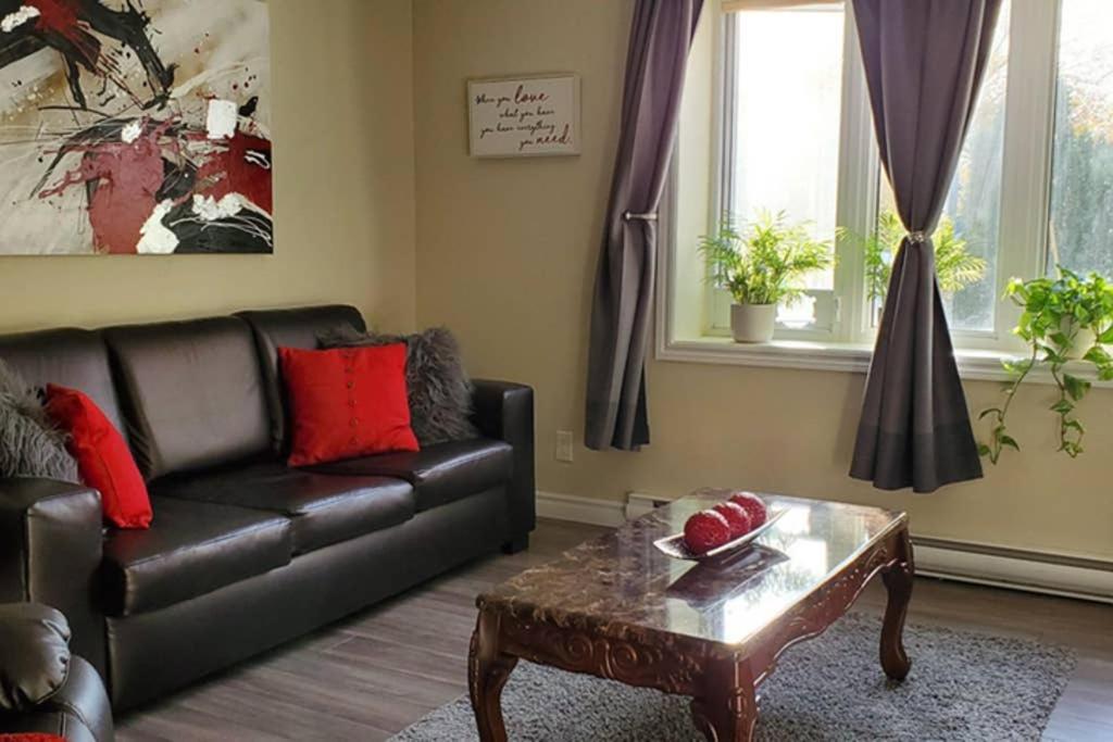 2-Bedroom Apartment Sweet #2 by Amazing Property Rentals في غاتينو: غرفة معيشة مع أريكة جلدية وطاولة قهوة