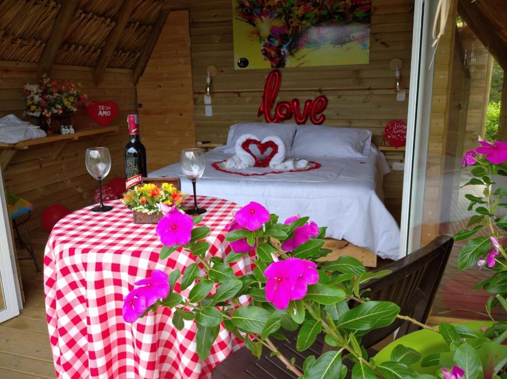 a table with two wine glasses and flowers on it at Glamping Paihuen in Villavicencio