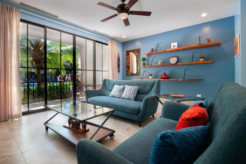 ein Wohnzimmer mit 2 blauen Sofas und einem Tisch in der Unterkunft Nicely Decorated Ground-Floor Unit in Front of Pool at Pacifico in Coco in Coco