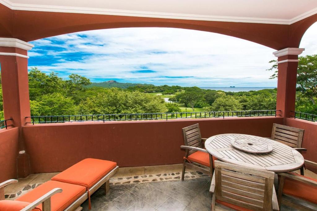 a balcony with a table and chairs and a view at Exclusive Home on Golf Course at Reserva Conchal is Stunning Inside and Out in Playa Conchal