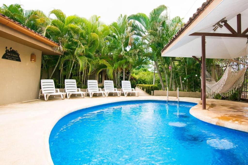 uma piscina com cadeiras e um guarda-sol em Charming unit that sleeps 4 - with pool - walking distance from Brasilito Beach em Brasilito