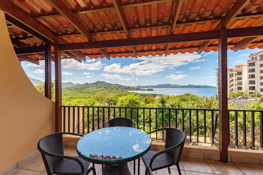 una mesa y sillas en un balcón con vistas al agua en Big-beautiful unit in Flamingo sleeps 8-with breathtaking ocean views, en Playa Flamingo
