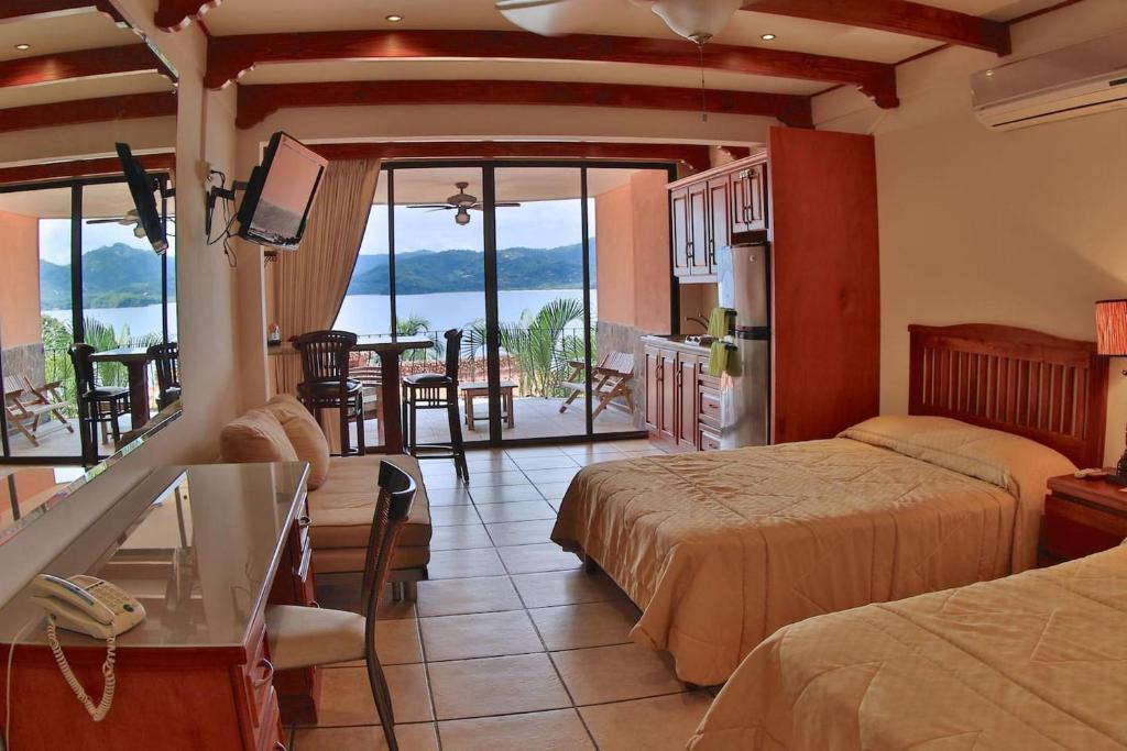 een hotelkamer met 2 bedden en uitzicht op de oceaan bij Hotel room-style ocean-view unit in Flamingo with pool in Playa Flamingo