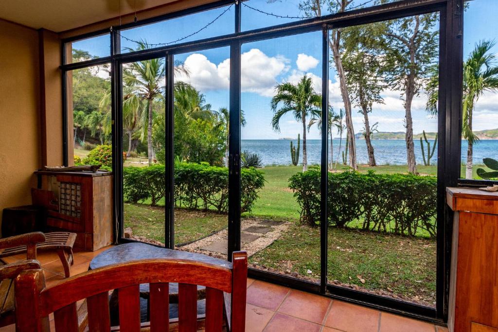 a screened in porch with a view of the ocean at Warm Interiors and Orange Hues on Ground Floor in Front of Beach in Playa Flamingo