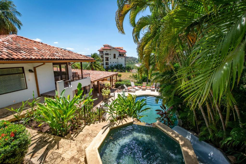 an image of a swimming pool in front of a house at Luxury Flamingo home with ocean view sleeps 10 - walking distance from beach in Playa Flamingo