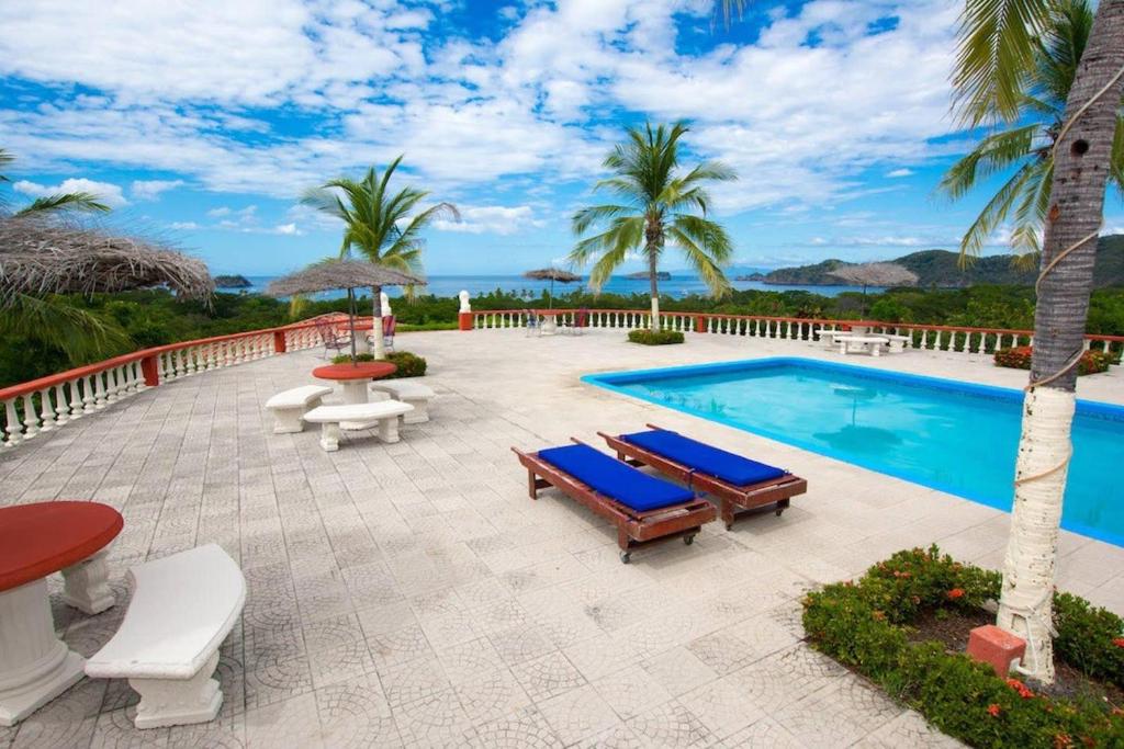uma piscina com espreguiçadeiras e cadeiras ao lado de um resort em Coco Joya Condo - pool with 180 ocean view - all in walking distance em Coco