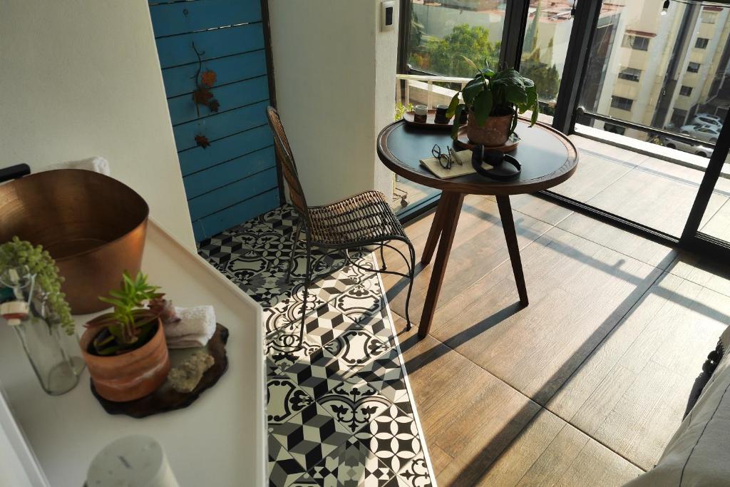 メキシコシティにあるLoft REMEDIOS - penthouse CDMX - áreas comunes compartidasの床にテーブルと椅子が置かれたバルコニー
