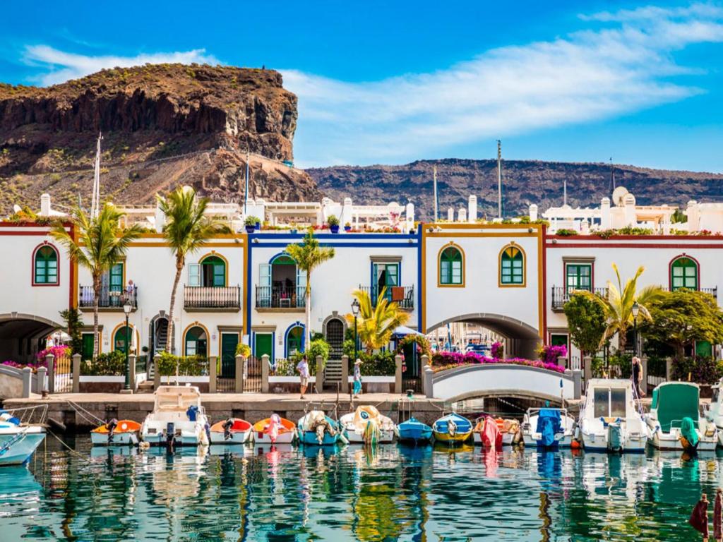 een groep boten in het water voor een gebouw bij Puerto De Mogan Castillete 4 in Puerto de Mogán