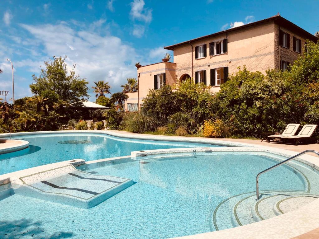 a large swimming pool in front of a house at Hotel Villa Maremonti in Marina di Massa