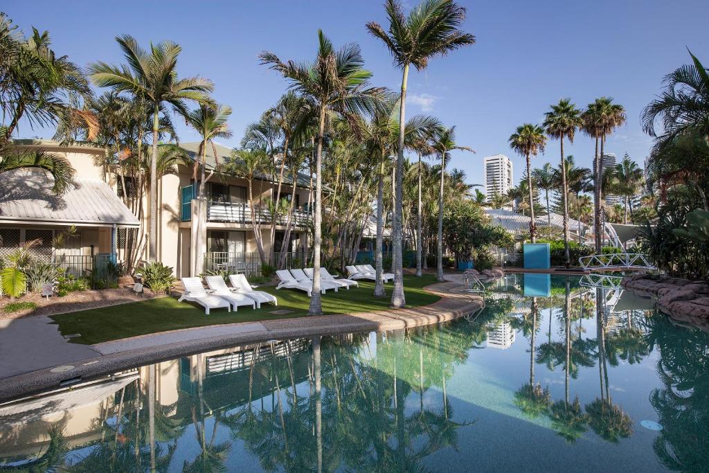 einen Pool in einem Resort mit Palmen in der Unterkunft BreakFree Diamond Beach in Gold Coast