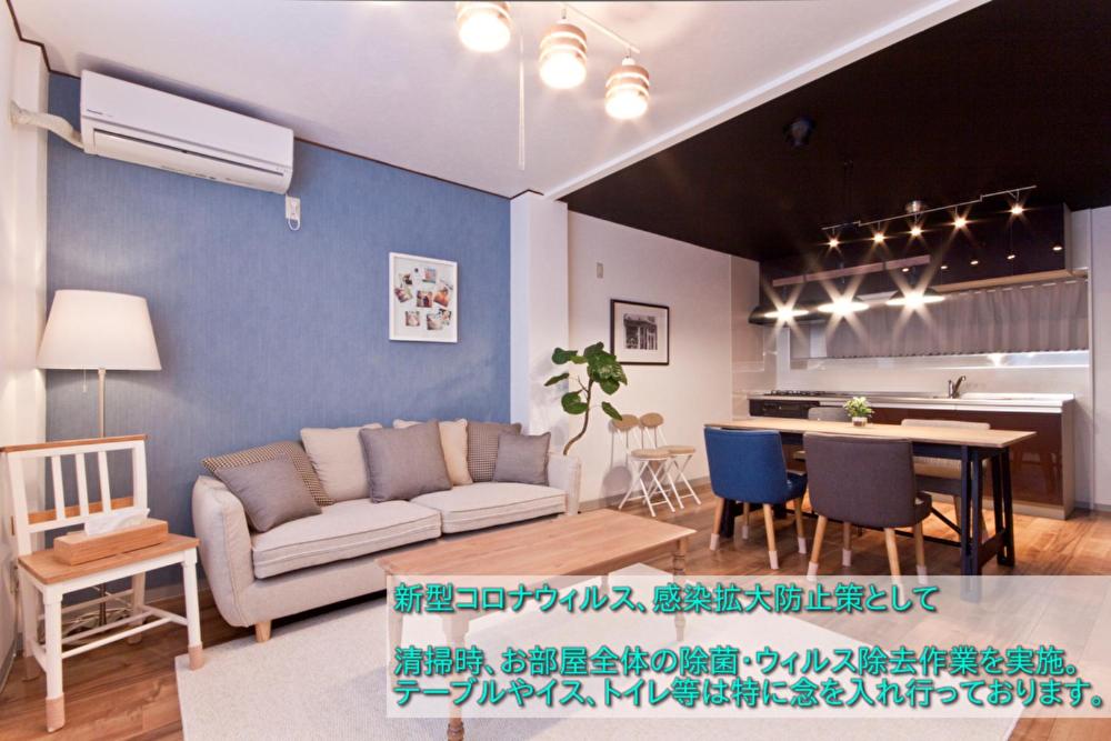 sala de estar con sofá y mesa en Guest House Re-worth Sengencho1, en Nagoya