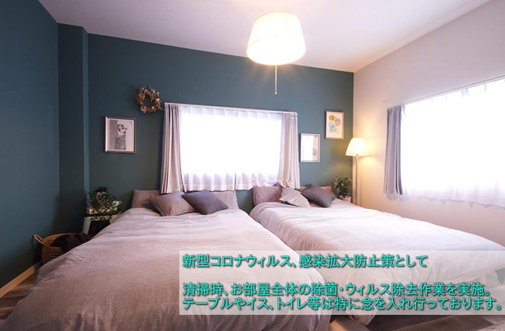 een slaapkamer met een groot bed en een raam bij Guest House Re-worth Joshin1 3F in Nagoya
