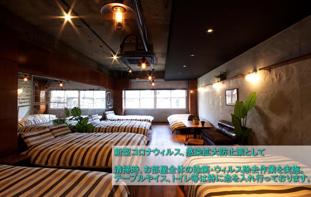 Großes Zimmer mit Sofas und Tischen. in der Unterkunft Guest House Re-worth Yabacho1 1F in Nagoya