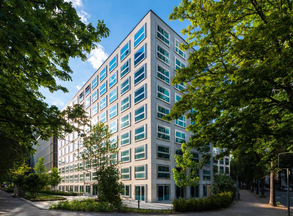 a white office building with trees in front of it at THE FLAG West M. in Frankfurt