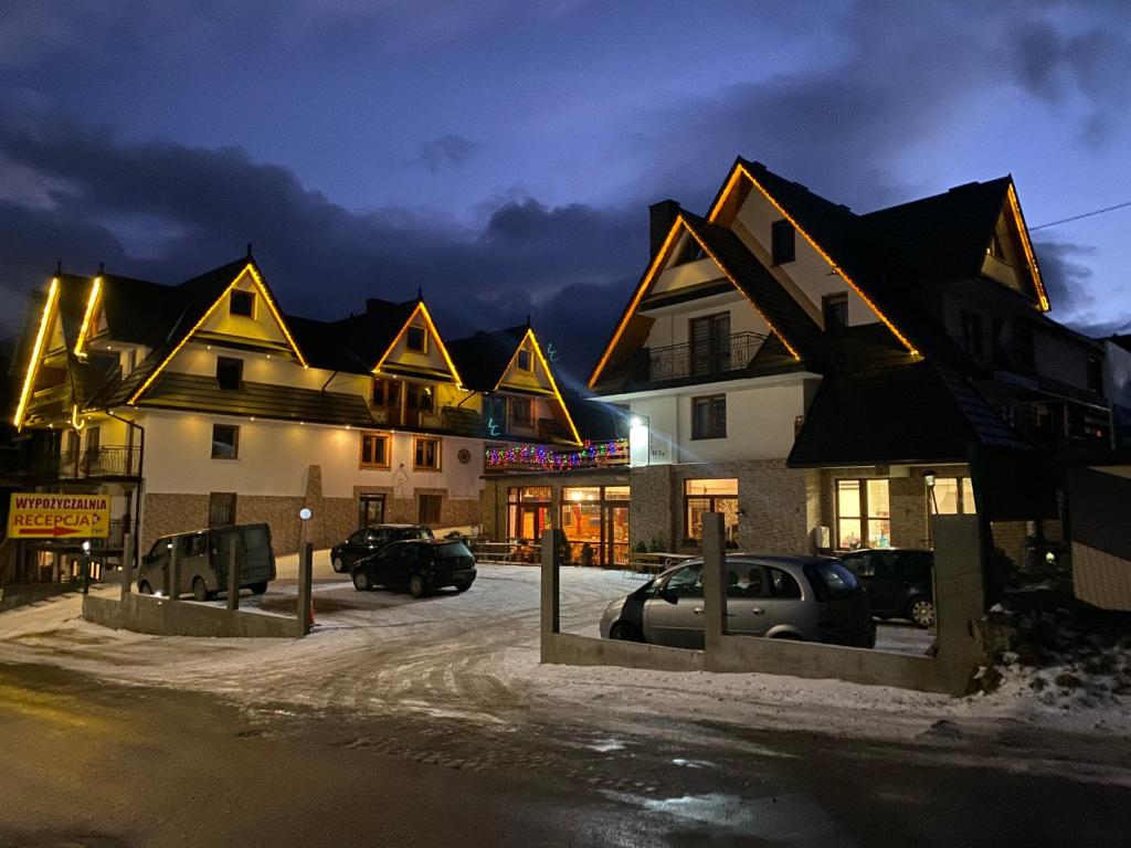 a group of houses with cars parked in a parking lot at Kompleks Wypoczynkowy Harnaś II in Kościelisko