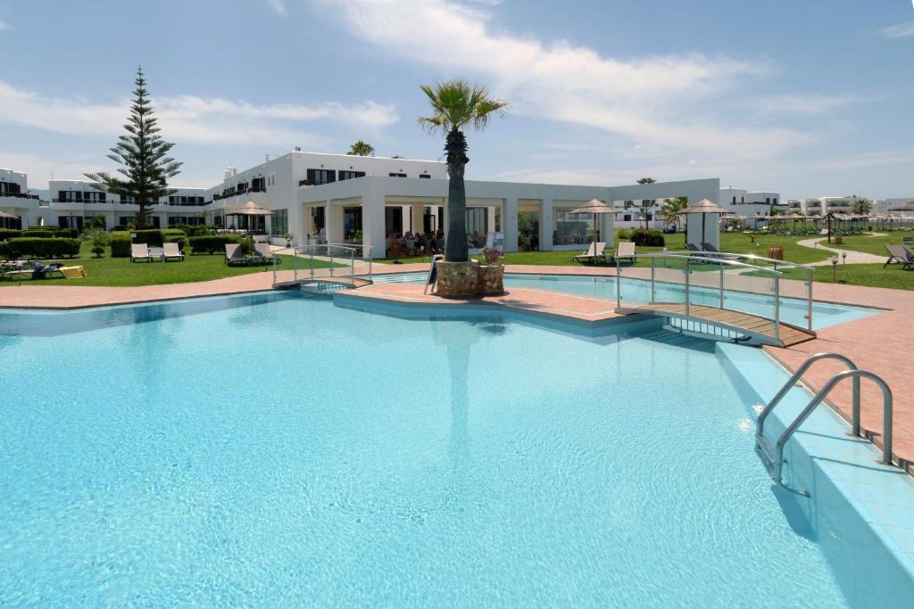 a large swimming pool in front of a building at Geraniotis Hotel and Resort in Platanias