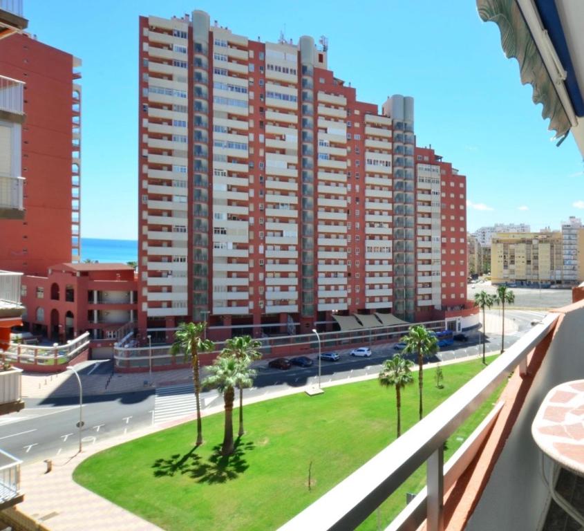 ein großes Apartmenthaus mit Palmen in einer Stadt in der Unterkunft NUEVO, con vistas al mar y a 70 metros de la playa in Cullera