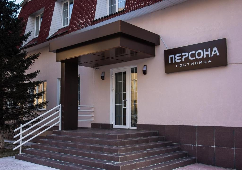 a building with a sign on the front of it at Hotel Persona in Abakan