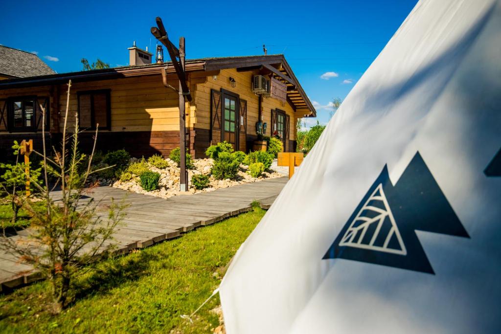 ein Haus mit einer Flagge vor einem Haus in der Unterkunft Western Camp Resort in Zator