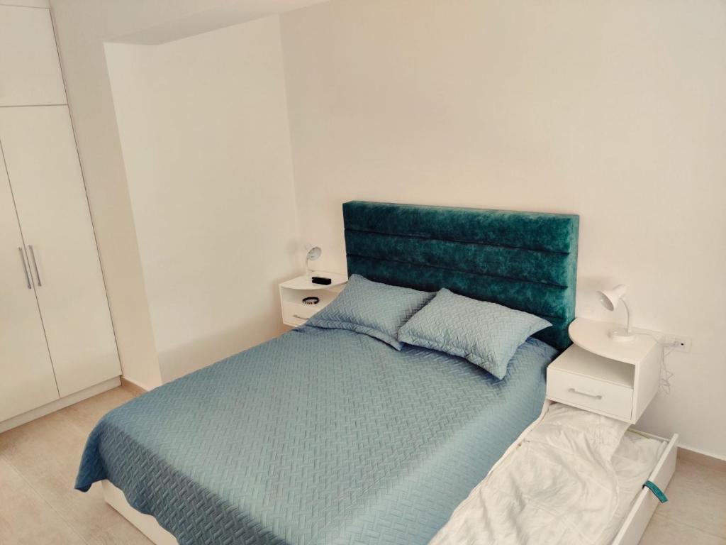 um quarto com uma cama com uma cabeceira verde em Saranda Terrace Apt. Rooms em Saranda