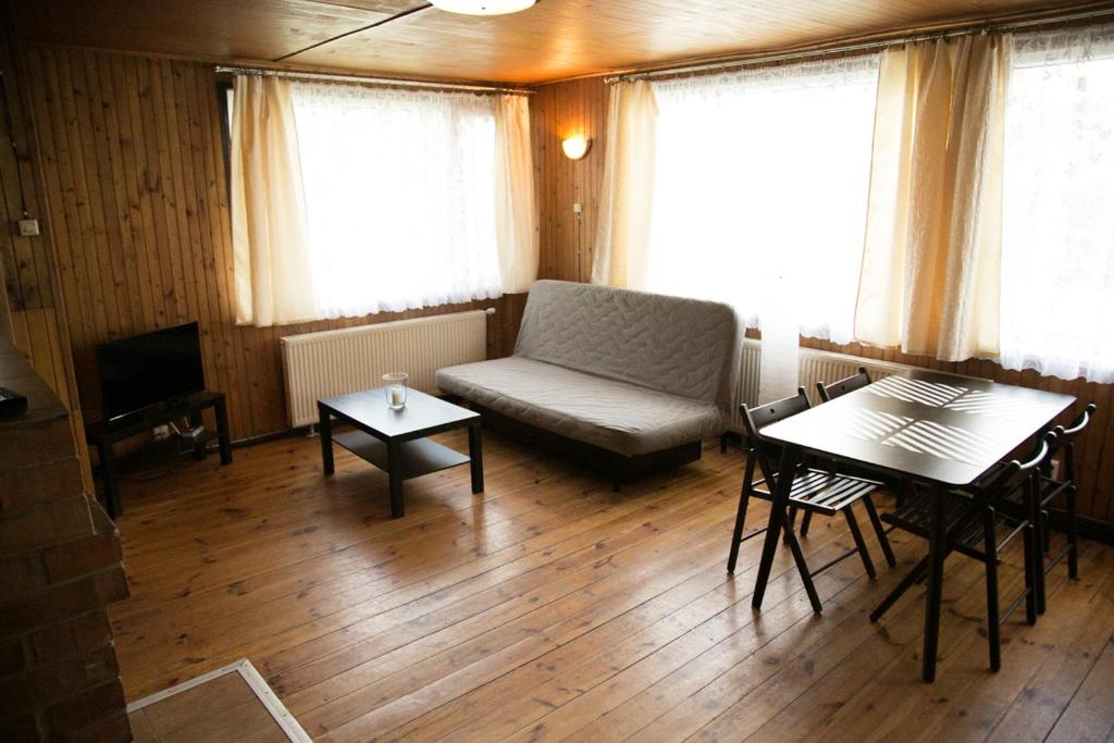 a living room with a couch and a table at Camping Oaza Błonie Kórnik Domki Standard - 3 pokoje in Kórnik