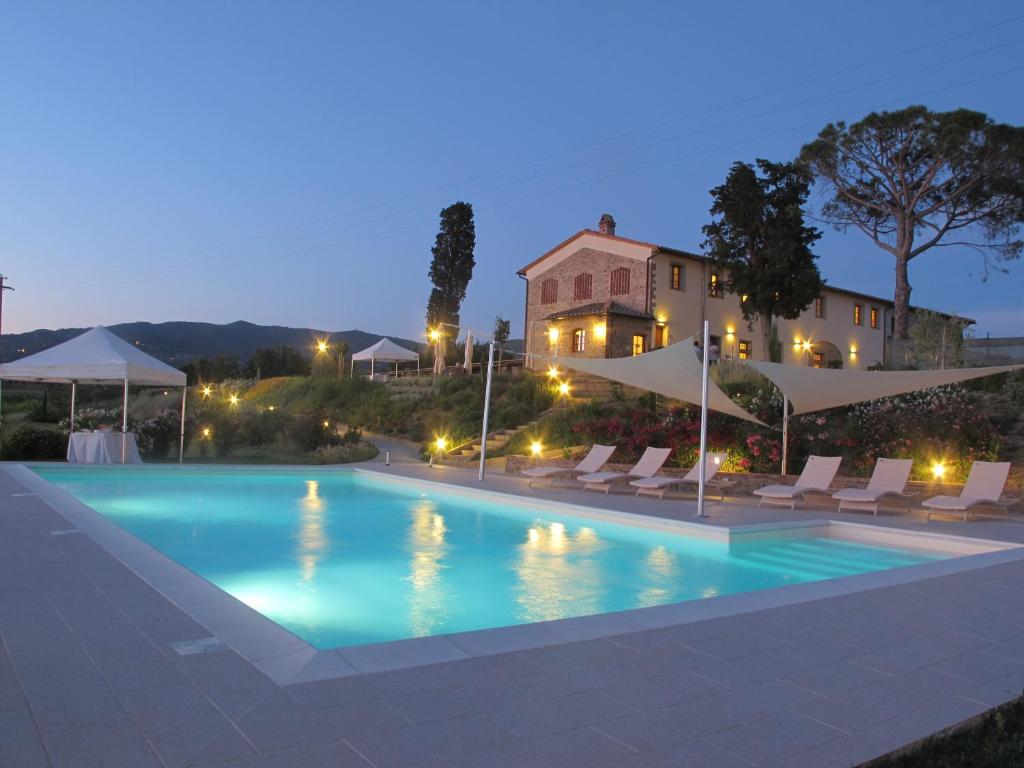 a swimming pool in front of a villa at night at Agriturismo Casetta I in Vinci