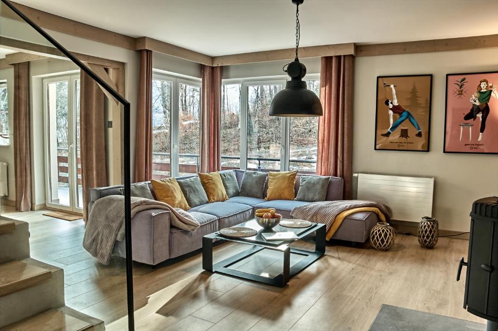 uma sala de estar com um sofá e uma mesa em Między Nami Apartamenty em Szczyrk