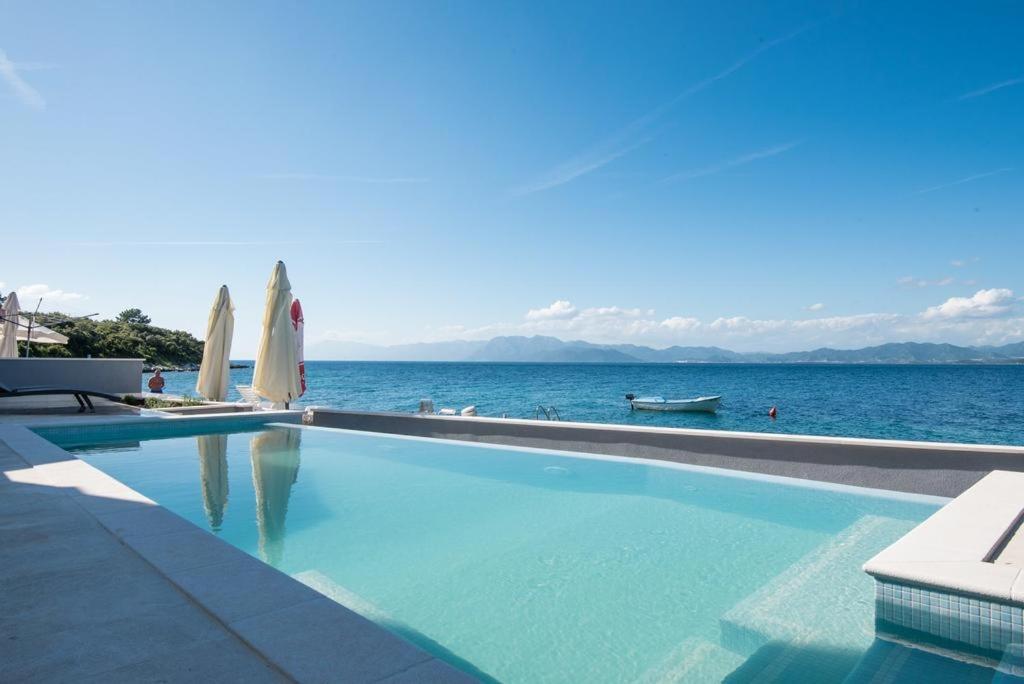 uma piscina com vista para o oceano em Apartments Poseidon em Sreser