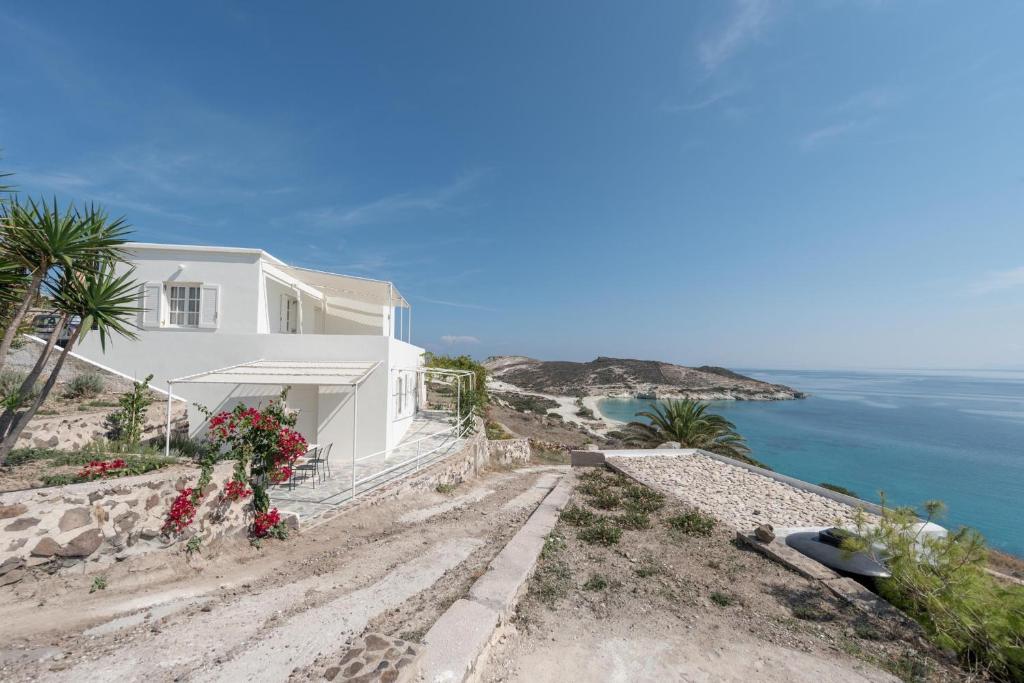 a white house on a hill next to the ocean at Kimolian Houses in Kimolos